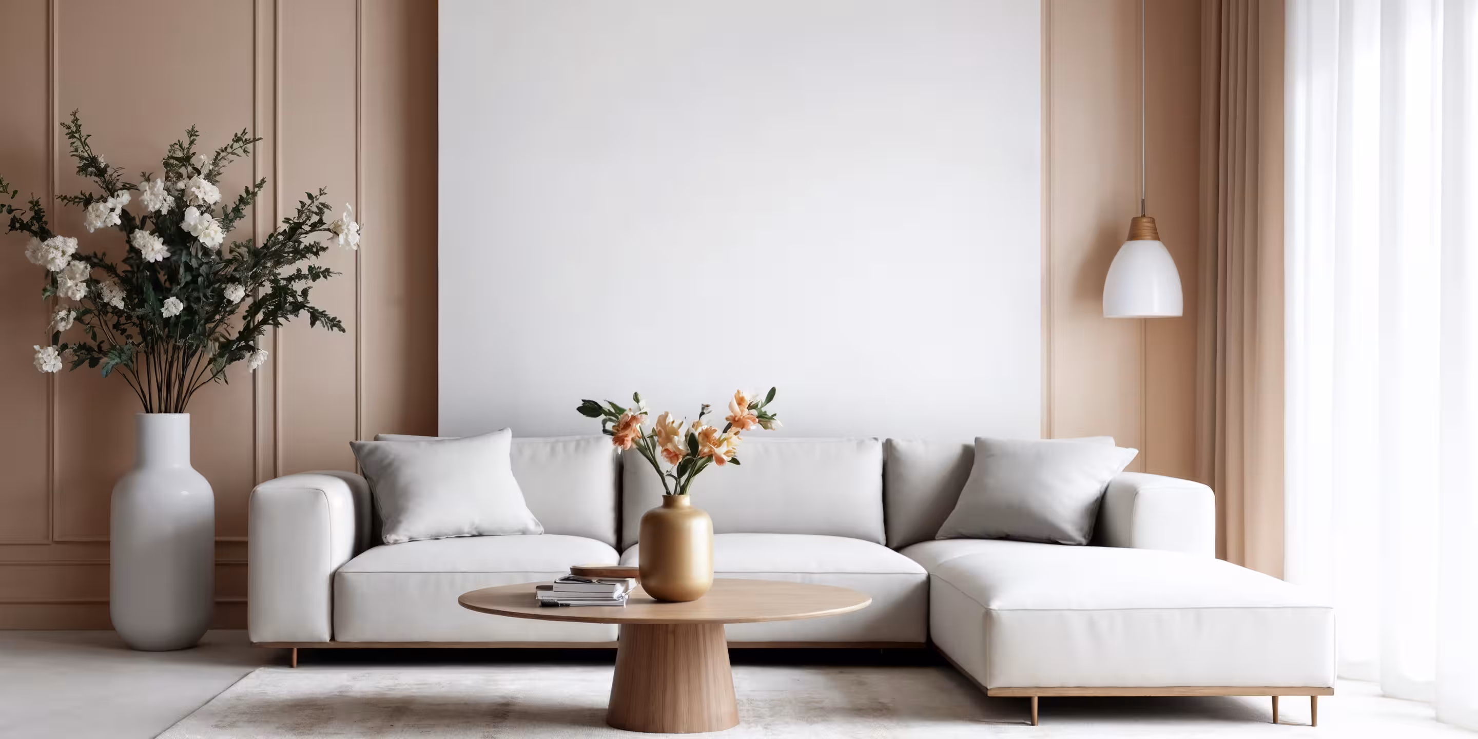 Modern living room with beige sofa, orange pillows, round gold coffee table, and wall-mounted TV.